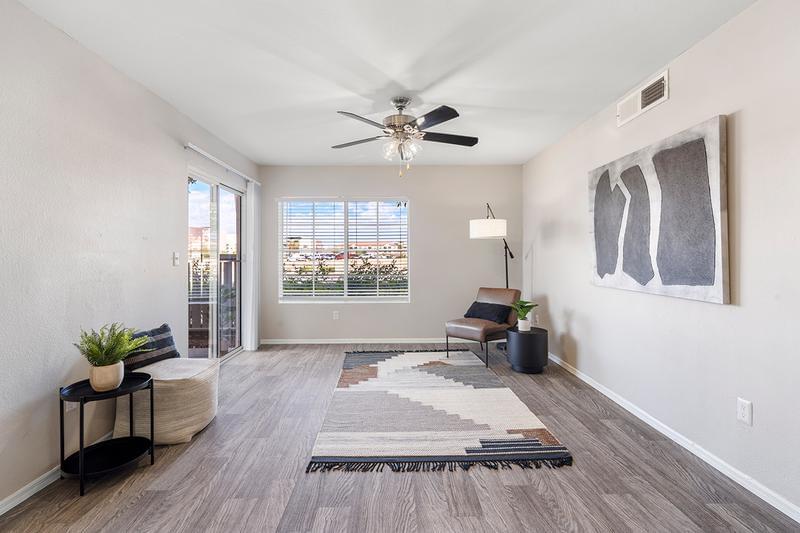 Living Room | Spacious living rooms featuring wood-style flooring, sliding doors to your private patio, and a multi-speed ceiling fan.