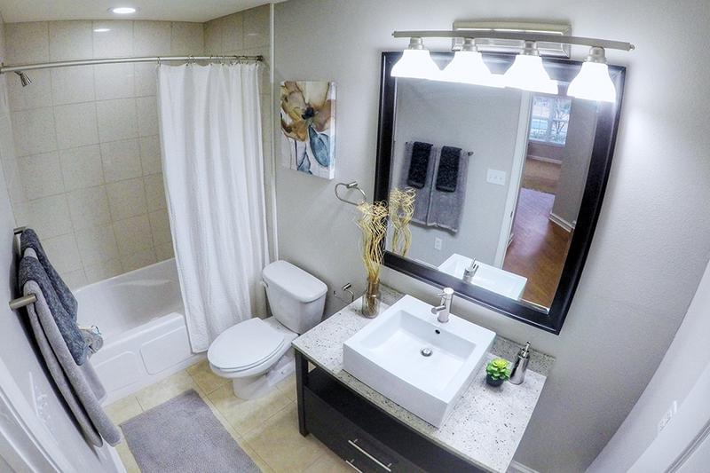 Bathroom | Spacious guest bathroom featuring granite-style countertops, state of the art brush nickel hardware and expansive mirror.