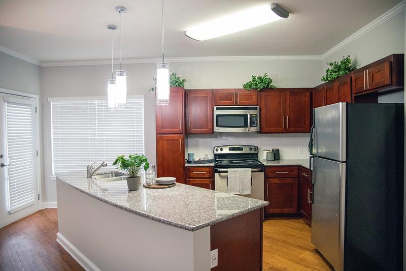 Breakfast Bar | Open kitchens featuring an expansive breakfast bar and updated pendant lighting.