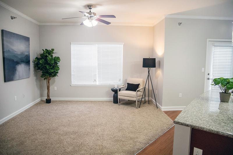 Spacious Living Room | Spacious open living rooms featuring multi-speed ceiling fans, plush carpeting and large windows.