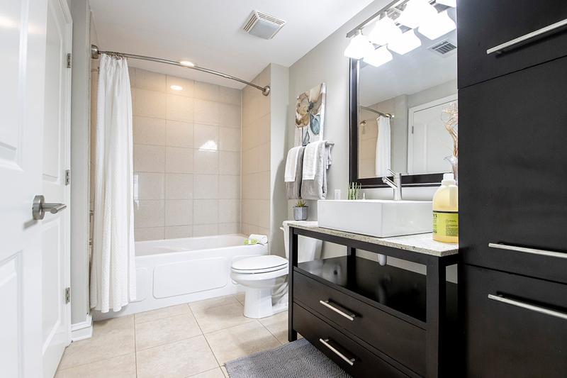 Bathroom | Spacious guest bathroom featuring granite-style countertops, state of the art brush nickel hardware and expansive mirror.