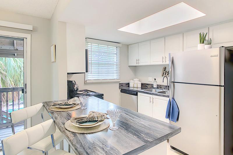 Renovated Black Fusion Kitchen | Newly renovated kitchens with updated white cabinetry and black fusion countertops. We are excited to offer in-person tours while following social distancing and we encourage all visitors to wear a face covering.