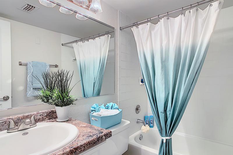 Bathroom | Bathroom featuring a granite-style vanity, wood-style flooring, and large mirror.