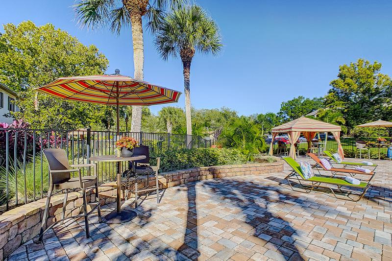 Poolside Tables | Have a snack by the pool at one of our poolside tables with umbrellas.