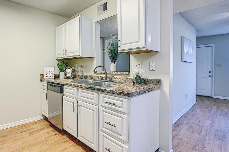 Updated Kitchens | Updated kitchens also feature white cabinetry and wood-style flooring.