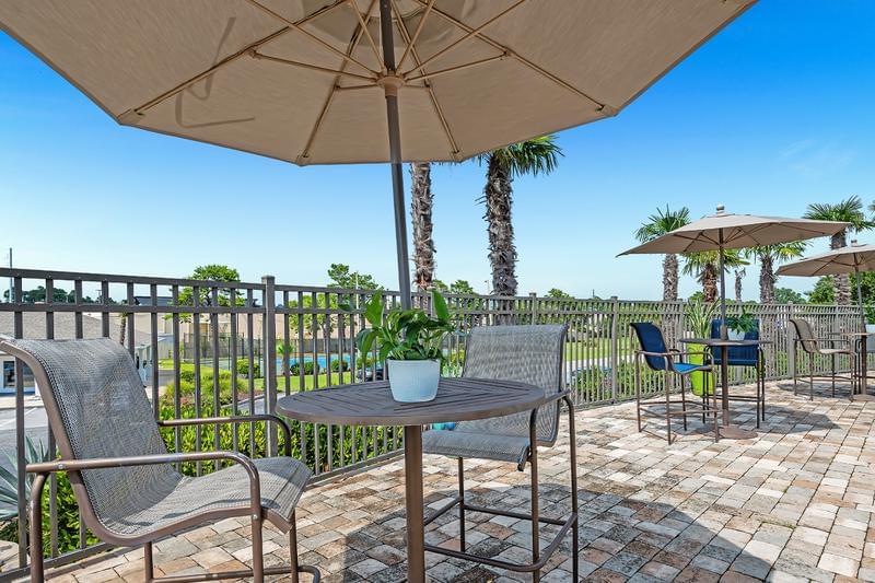 Poolside Tables | Sit by the pool under the shade of our umbrellaed tables.