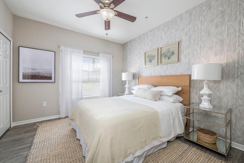 Master Bedroom | Our spacious bedrooms feature wood-style flooring and a ceiling fan.