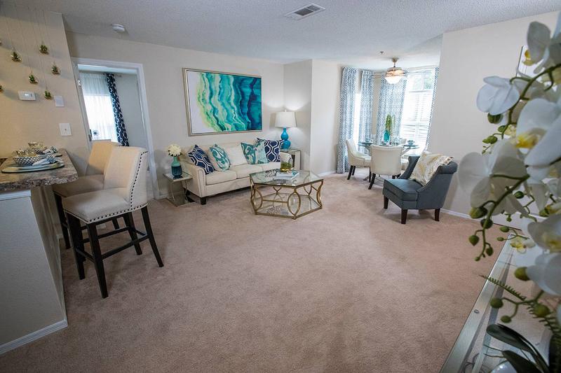 Living Room | Spacious living rooms with plush carpeting and a solarium, which is a perfect place for a small dining room table.