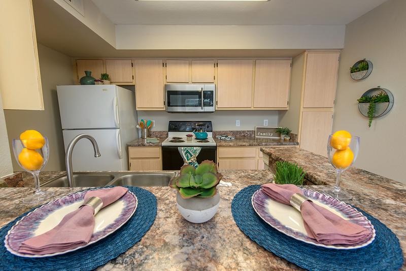 Kitchens | Spacious kitchens featuring granite-style countertops and wood-style flooring.