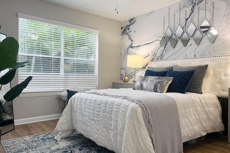 Master Bedroom | Spacious bedrooms featuring a ceiling fan, walk-in closets, and large windows allowing natural sunlight to shine through.