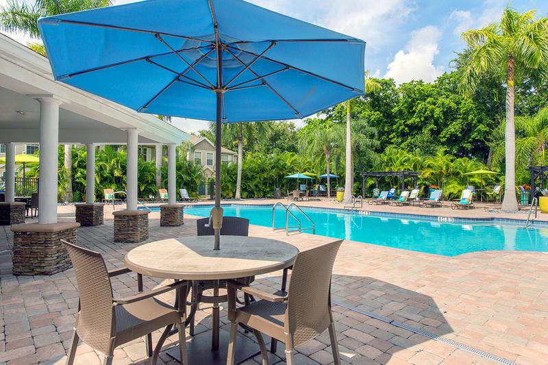 Poolside Tables | Enjoy sitting under one of our poolside tables with umbrellas.
