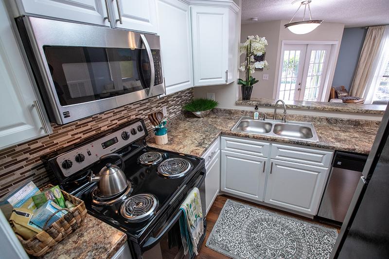 Modern Kitchens | Updated kitchens featuring granite-style counter tops, white cabinetry, and wood-style flooring.