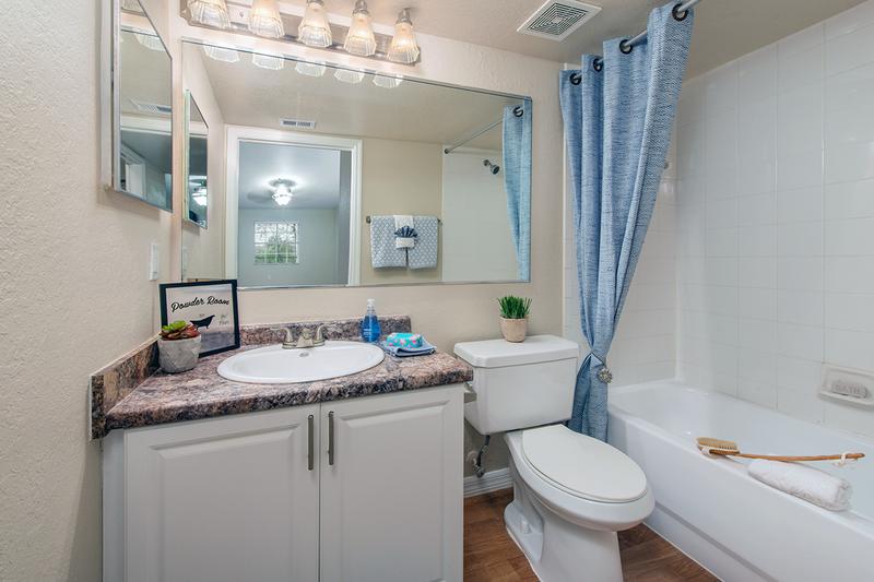 Master Bathroom | Master bedrooms feature a master bathroom with granite-style counters, wood-style flooring, and large mirrors.