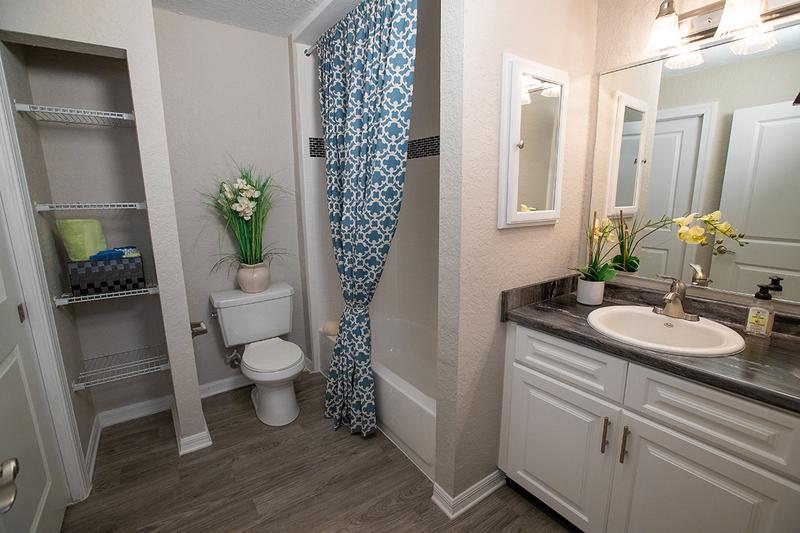 Updated Bathrooms | Newly renovated bathrooms featuring large mirrors, black fusion counter tops, and wood-style flooring.