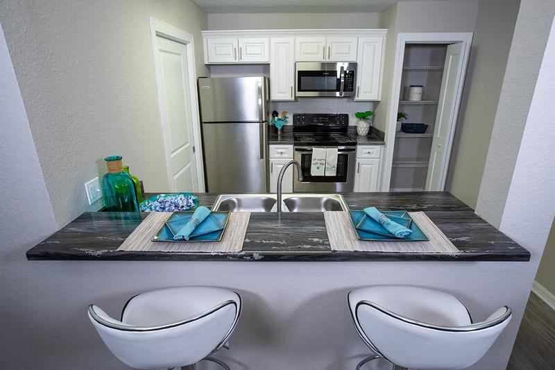Newly Remodeled Kitchens | Your newly renovated kitchen features black-fusion countertops, wood-style flooring, and stainless steel appliances.