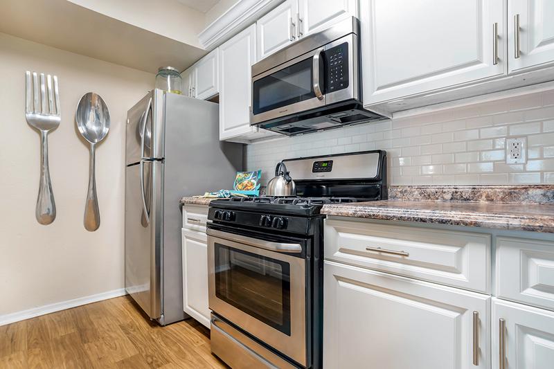 Kitchen | Newly remodeled kitchen featuring granite-style counter-tops, a back-splash, and stainless steel appliances.