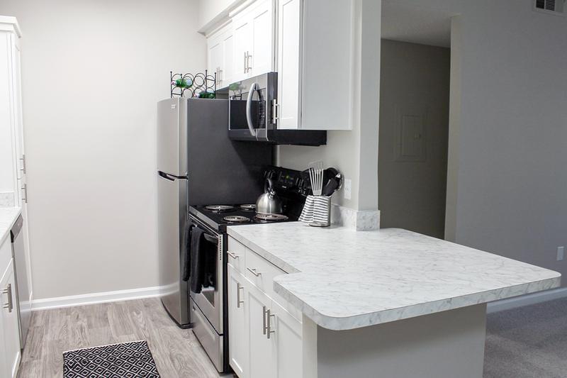 Kitchen Island | Select apartments feature Carrara marble countertops with an island overlooking the living area.