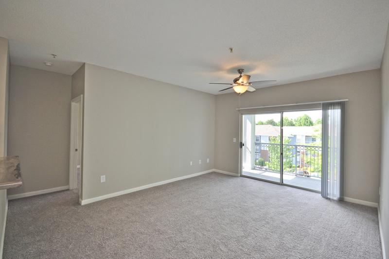 Living Room | Spacious living rooms featuring plush carpeting and sliding doors to your very own private patio.
