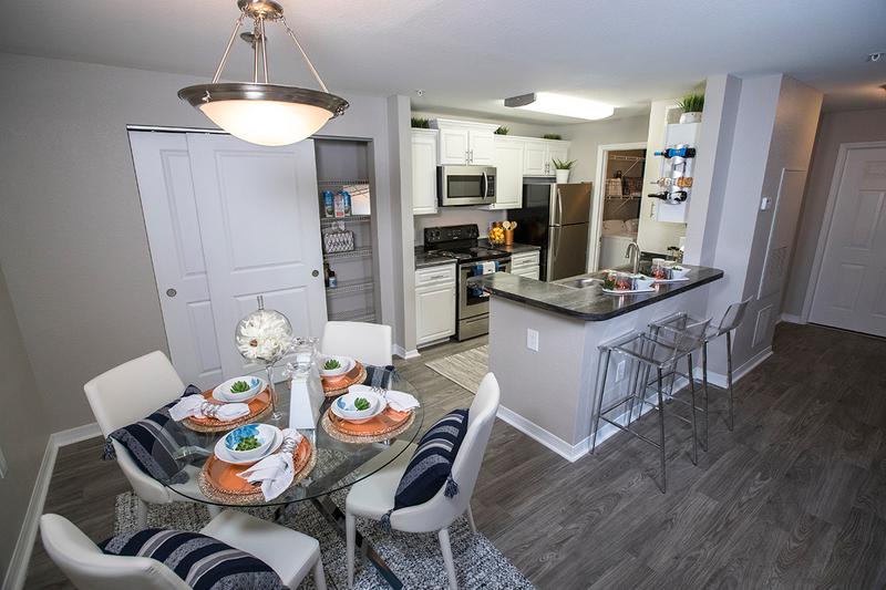 Dining Area | Separate dining area located next to the kitchen featuring contemporary lighting and wood-style flooring.