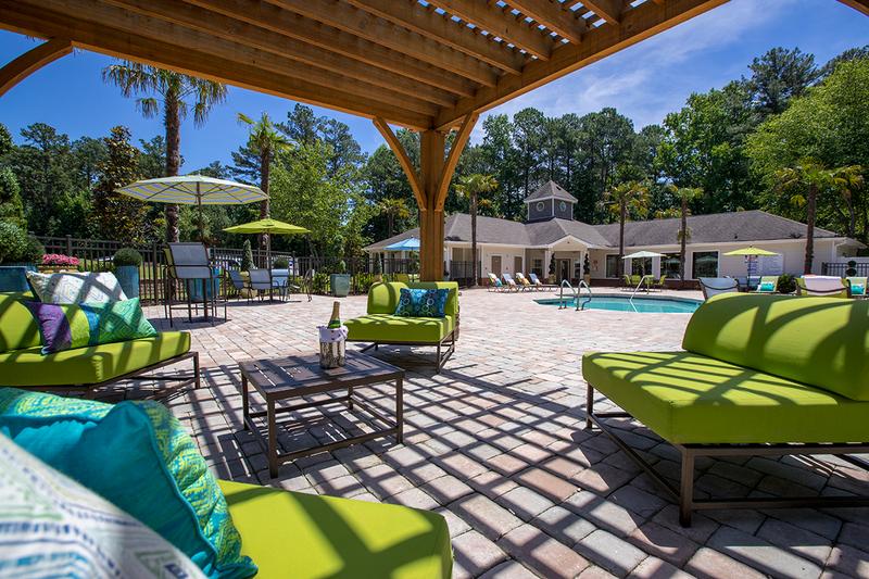 Poolside Pergola | Relax in the shade under the poolside pergola featuring comfortable seating.