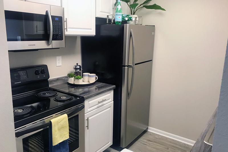 Updated Kitchens | Updated kitchens featuring stainless steel appliances, black-fusion counter tops and white cabinetry.