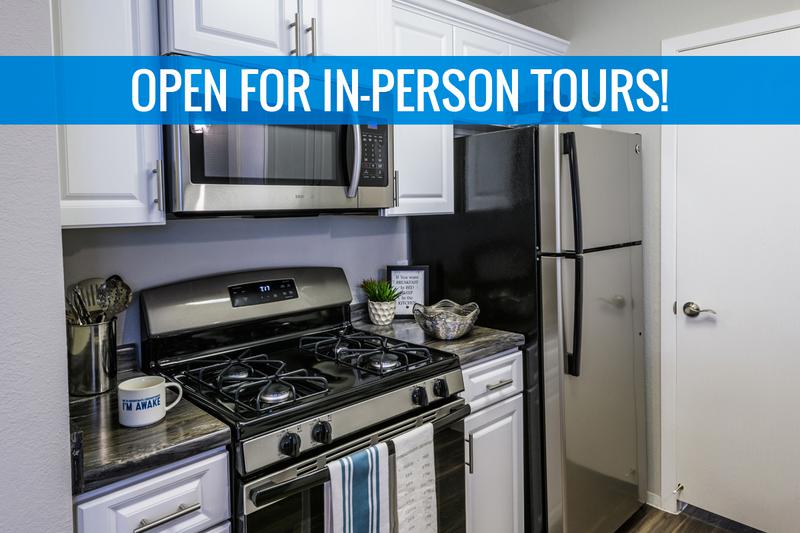 Renovated Kitchens - In Select Homes | Renovated kitchens featuring black fusion counter tops, wood-style flooring, and stainless steel appliances. We are excited to offer in-person tours while following social distancing and we encourage all visitors to wear a face covering.