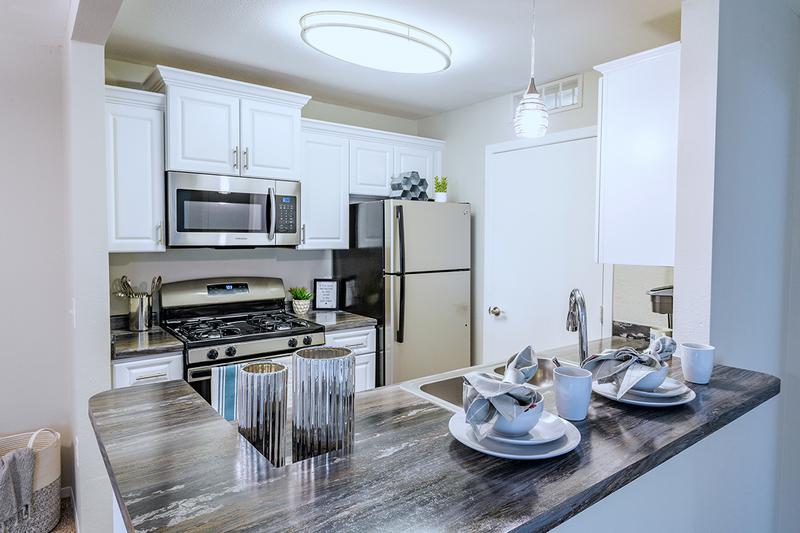 Galley Style Kitchens | Enjoy galley-style kitchens featuring wood-style flooring and ample cabinetry.