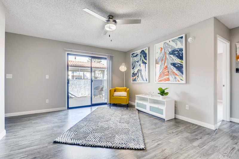 Living Room | Spacious living rooms featuring wood-style flooring, multi-speed ceiling fans and sliding doors to your private patio.