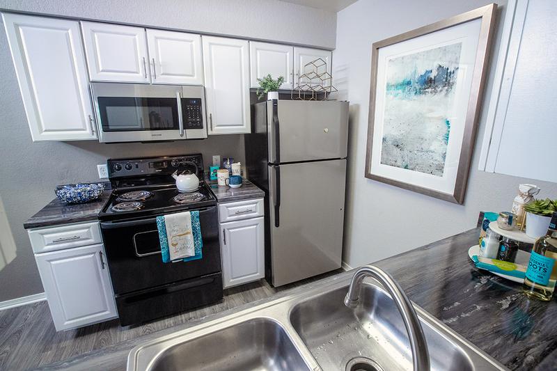 Renovated Kitchens | Newly renovated kitchens featuring stainless steel and black appliances and modern white cabinetry.