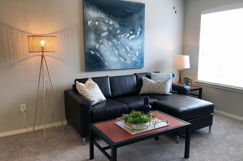 Furnished Living Room | Furnished living room features a couch, coffee table, side table and entertainment center.