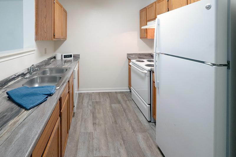 Galley Style Kitchen | Galley style kitchens featuring wood-style flooring, updated countertops, and ample cabinetry.