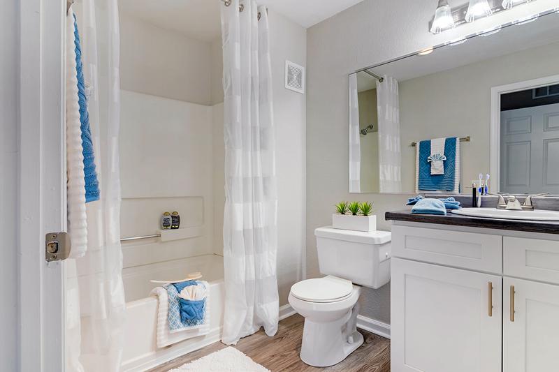 Bathroom | Bathrooms featuring wood-style flooring and large mirrors and vanities.