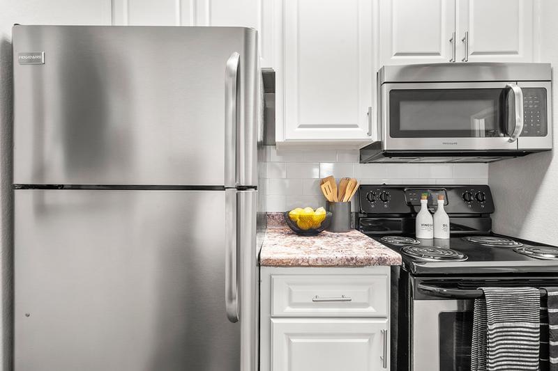 Stainless Steel Appliances | Newly remodeled kitchen with white cabinetry and granite-style counter tops.