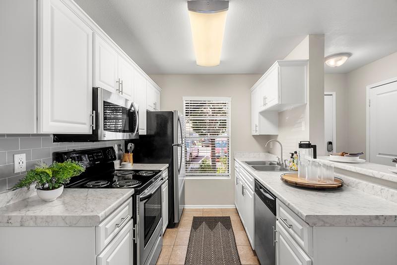 Beautifully Remodeled Kitchen | Newly remodeled kitchens featuring marble-style countertops, wood-style and tile flooring, with stainless steel appliances.