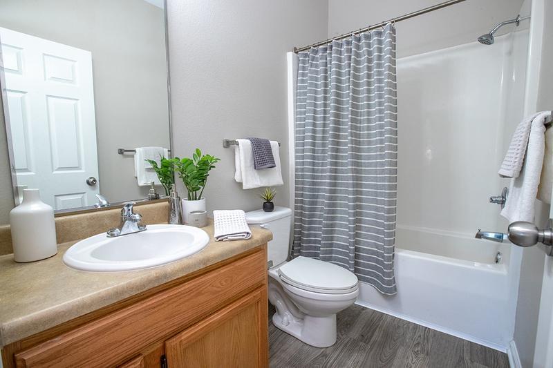 Guest Bathroom | Bathrooms featuring wood-style flooring, large mirrors and brush nickel hardware features.