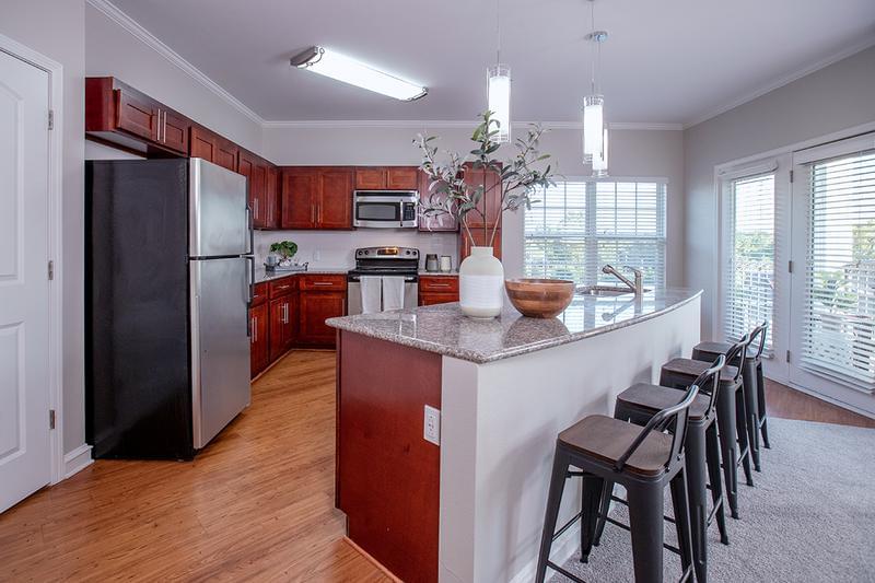 Open Kitchens with Granite Countertops | Our gorgeous two bedroom kitchen layouts with cherry wood cabinetry and granite countertops offer a perfect environment for entertaining and relaxing.