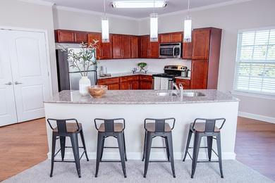 Breakfast Bar with Pendant Lighting | Entertain in your open kitchen featuring an expansive breakfast bar and updated pendant lighting.