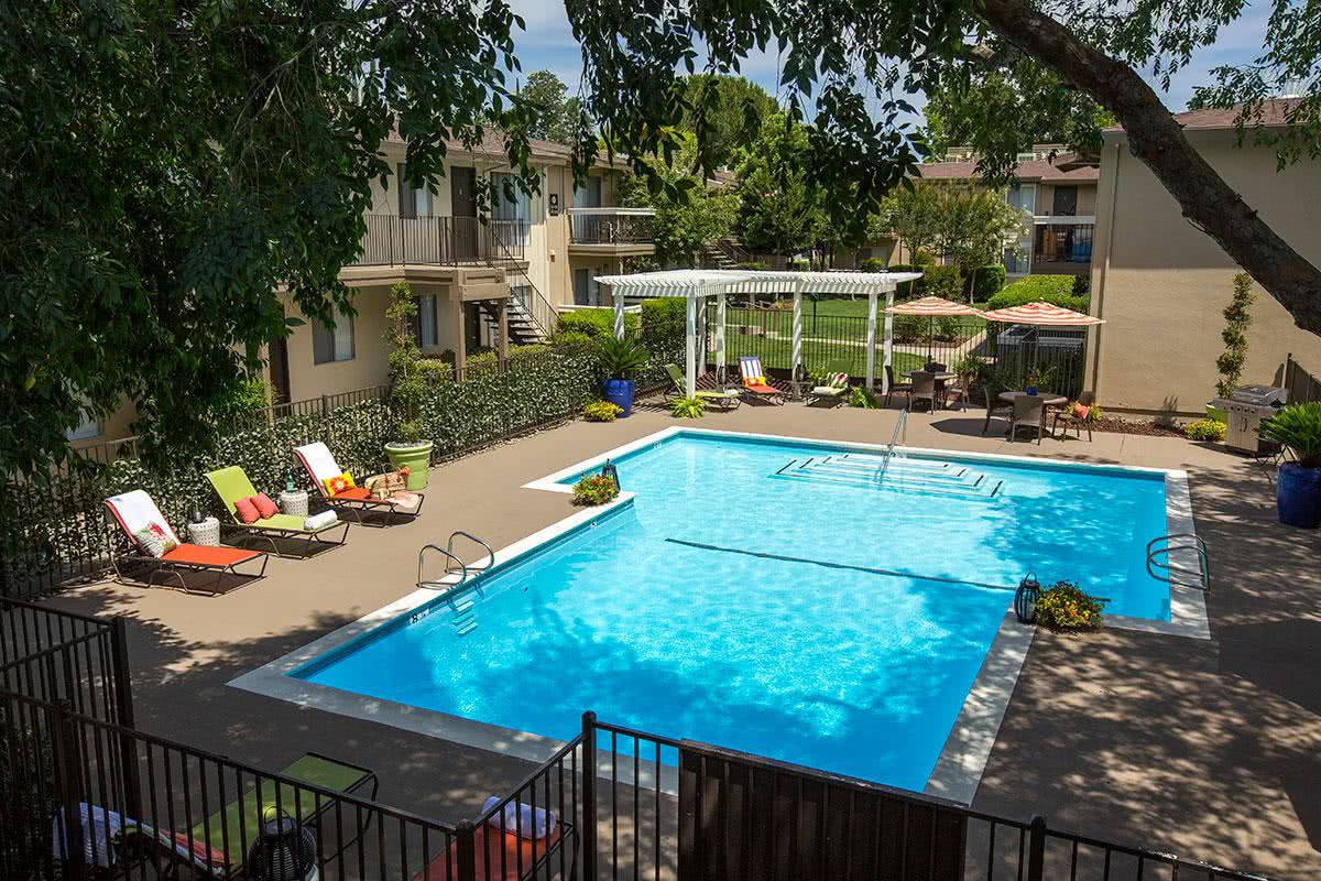 Newly renovated pool area with resort style furniture and a newly built trellis area with seating.