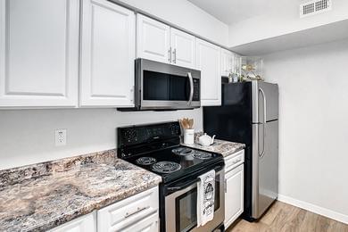 Kitchen | Newly updated kitchens featuring granite-style counter tops, updated white cabinetry, and stainless steel appliances.