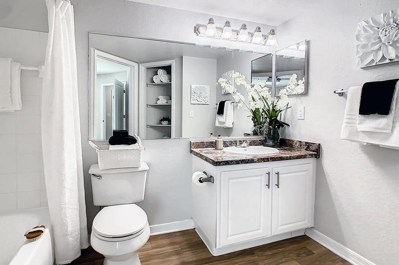 Primary Bathroom | Primary bathroom featuring granite-style counter tops, wood-style flooring and a linen closet. 