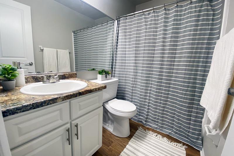 Bathroom | Every bathroom is newly remodeled featuring updated countertops, cabinetry, and wood-style flooring.