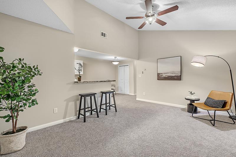 Living Room | Spacious, open living rooms featuring plush carpeting and a ceiling fan. 
