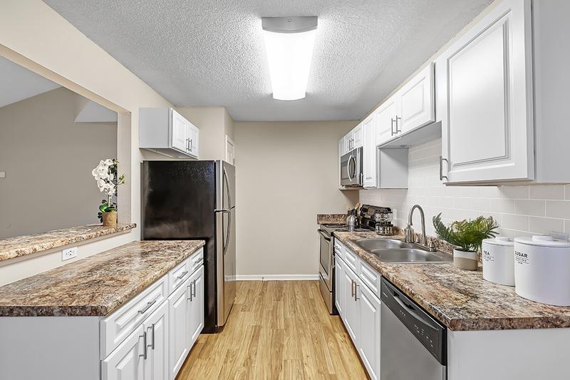 Galley Style Kitchens | Galley style kitchens featuring wood-style flooring, granite-style countertops, and a subway tile backsplash.