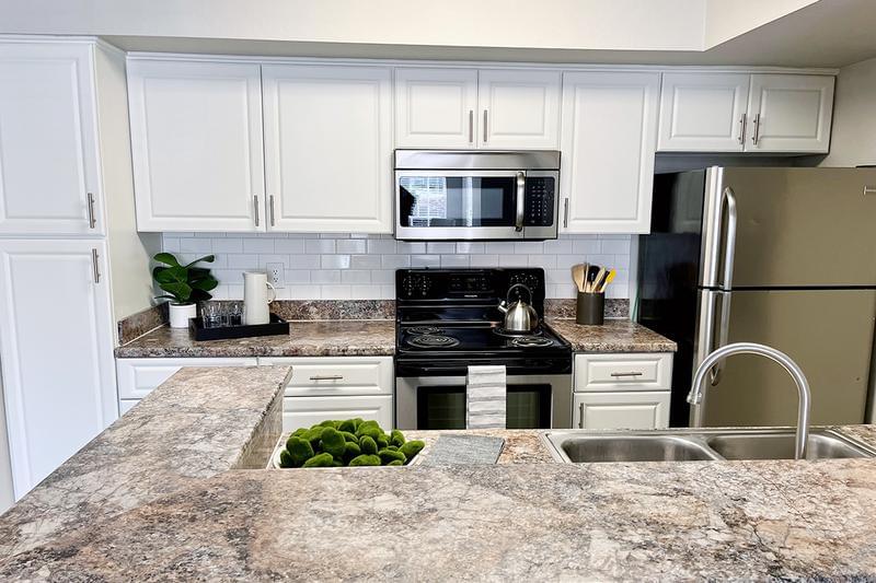 Kitchens | Spacious kitchens featuring granite-style countertops and wood-style flooring.