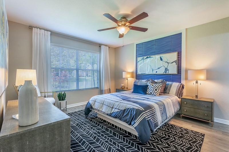 Master Bedroom | Spacious bedrooms featuring plush carpeting, large windows, and a ceiling fan.