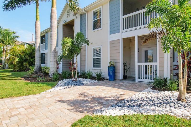 Building Exterior | Enjoy the lush landscaping and palm trees surrounding the gated community.