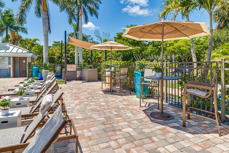 Poolside Tables and Grill | Our expansive sundeck features plenty of tables with umbrellas as well as a gas grill so you can cook out by the pool.