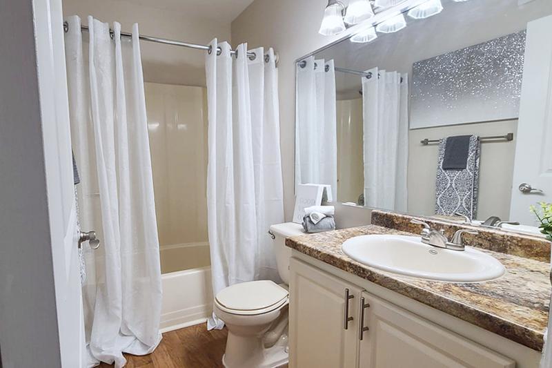 Large Bathroom Vanities | Our classic bathrooms feature wood-style flooring, granite-style countertops, and a large mirror.