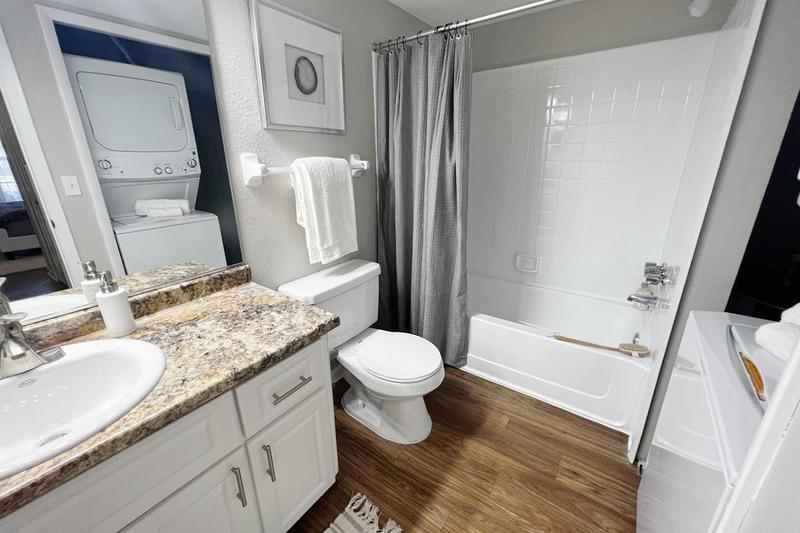 Bathroom | Designer bathroom with new granite style counter tops and modern vanity with exceptional storage space.