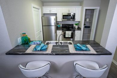 Newly Remodeled Kitchens | Your newly renovated kitchen features black-fusion countertops, wood-style flooring, and stainless steel appliances.